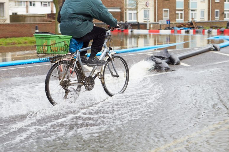 Cyclist On Flooded Urban Road